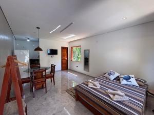 a room with two beds and a desk and a table at Chalé Encanto Paraty in Paraty