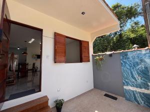 a house with a large window and a patio at Chalé Encanto Paraty in Paraty