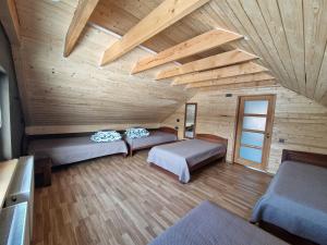 a room with two beds in a wooden cabin at Gardenvillage house in Daržininkai