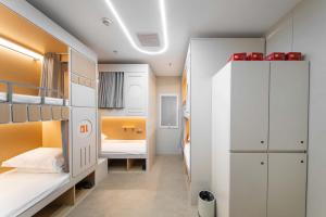 a dorm room with two bunk beds and a bathroom at SilMiCore Hostel in Shanghai