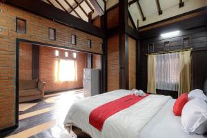 a bedroom with a large bed in a brick wall at RedDoorz @ Cilandak Timur in Jakarta