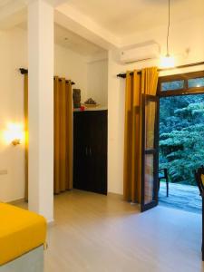 a room with a bed and a large window at Unawatuna Backpacker Lodge in Unawatuna