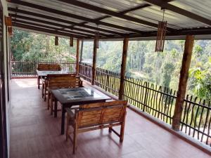 a porch with tables and chairs on a balcony at Ella Field Side View Rooms & Cafe in Demodera