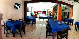 a dining room with blue tables and black chairs at Hotel Wagelia Turrialba in Turrialba
