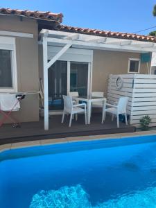 a patio with a table and chairs next to a swimming pool at ΑVLI Superior Studio Sarti no6 in Sarti