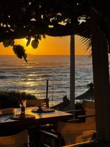 a table with a view of the ocean at sunset at Kallmi View - Nature Retreat on the Albanian Adriatic Coast in Durrës