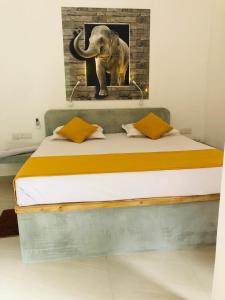 a bed with a picture of an elephant on the wall at Unawatuna Backpacker Lodge in Unawatuna