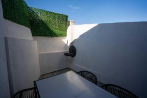 a table and two chairs on a balcony with green plants at Macaron The Pure Guest Houses in Ayvalık +19 photos