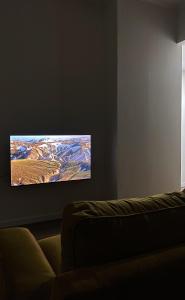 a living room with a flat screen tv on a wall at stefanias apartment in Tirana
