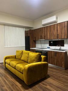 a living room with a yellow couch in a kitchen at stefanias apartment in Tirana