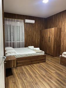 a bedroom with a bed and a wooden wall at stefanias apartment in Tirana
