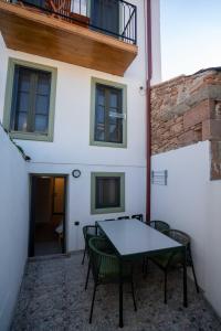 a patio with a table and chairs in front of a building at Macaron The Pure Guest Houses in Ayvalık