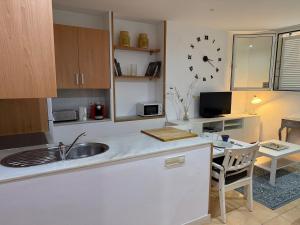 a kitchen with a sink and a clock on the wall at Casa de Mar in Lloret de Mar