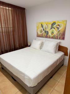 a bed in a bedroom with a painting on the wall at Casa de Mar in Lloret de Mar