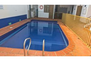 a large blue swimming pool with a red tile floor at Hotel Pisci Stars Sra in Saravena