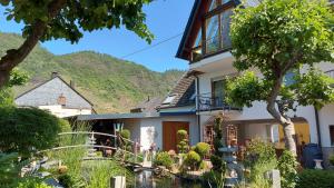 a house with a hill in the background at Ferienwohnung Pellenz in Bremm