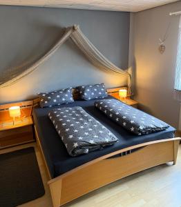 a bedroom with a bed with a canopy and pillows at Ferienwohnung Pellenz in Bremm