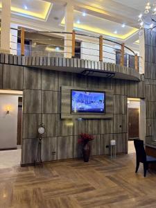 eine Lobby mit einem Flachbildfernseher an der Wand in der Unterkunft Brava Hotel in Ibadan