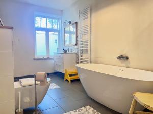 a bathroom with a large white tub and a toilet at Wendlandhof Lüggau in Dannenberg +115 photos