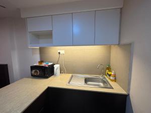 a small kitchen with a sink and a microwave at EasyStay Studio Apartment KBCP in Kota Bharu