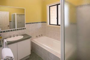 a bathroom with a tub and a sink and a mirror at Waterside View in Augusta