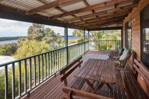 a porch with a wooden bench and a view of the water at Waterside View in Augusta