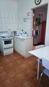 a kitchen with a stove and a sink and a table at Eagles guest house Piet Retief in Piet Retief
