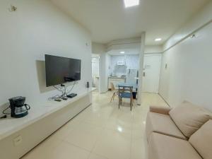 a living room with a couch and a flat screen tv at Biarritz praia in São Luís