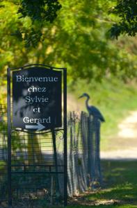 un cartel en un parque con un pájaro en una valla en Domaine de la Cour, en Sainte-Gemme-dʼAndigné