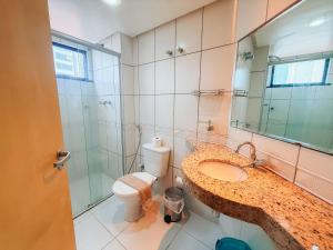 a bathroom with a toilet and a sink and a mirror at Biarritz praia in São Luís +8 photos