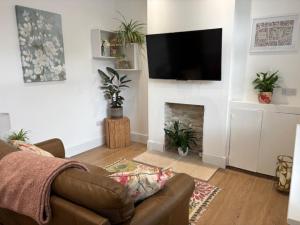 a living room with a couch and a fireplace at Stylish Didsbury House in Manchester