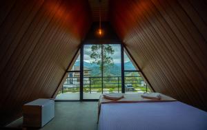 a bedroom with a bed and a large window at Green Infinity Resort in Diyatalawa +10 photos