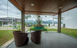 a screened in porch with two chairs and windows at Green Infinity Resort in Diyatalawa