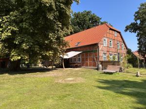 a large brick building with a tree in front of it at Wendlandhof Lüggau in Dannenberg