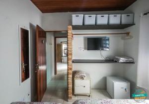 a room with a bed and a tv on a wall at hostel Bike Point Caraguatatuba in Caraguatatuba