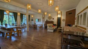 a living room with wooden floors and tables and chairs at Shambhala in Czarnów