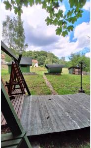 a wooden deck with a building in a field at Shambhala in Czarnów