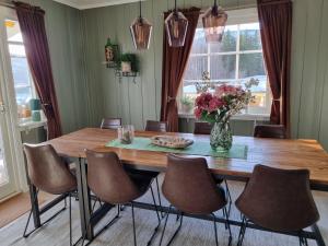 a dining room table with chairs and a vase of flowers at Solhaug in Torpo
