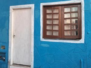 a blue building with a door and a window at Casa blue in Aracati +3 photos