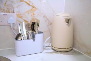 a container of kitchen utensils sitting on a counter at Modern Airport Annexe - Free Parking - Sleeps 4 - Near Luton Airport in Luton