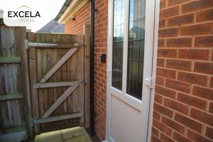 an open door on a brick wall next to a house at Modern Airport Annexe - Free Parking - Sleeps 4 - Near Luton Airport in Luton