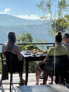 a group of people sitting at a table on a patio at Misty Knuckles Cabana in Rangala +23 photos