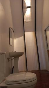 a small bathroom with a toilet and a sink at Misty Knuckles Cabana in Rangala