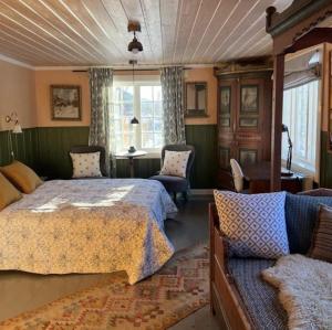 ein Schlafzimmer mit einem Bett und einer Couch in der Unterkunft Sevletunet B&B and Cabins in Rødberg + 104 Fotos
