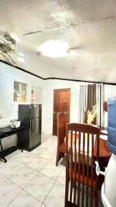 a kitchen with a refrigerator and a table and chairs at Triple K Transient House in Butuan