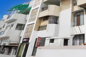 a white building with windows and a sign on it at SPOT ON Hotel prayag villa in Allahābād +21 photos