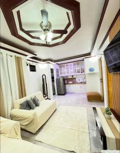 a living room with a couch and a ceiling at Triple K Transient House in Butuan