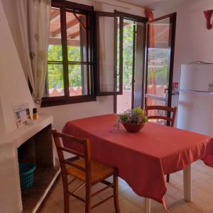 a kitchen with a red table with chairs and a refrigerator at Casa LeMa in Geremèas