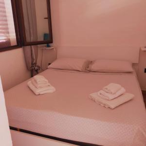 a bedroom with two beds with towels on them at Casa LeMa in Geremèas