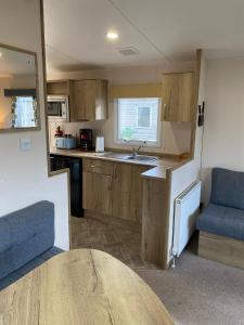 a small kitchen with a sink and a table at 230 Unity Holiday Resort 6 Birth cosy and secure property next to all shops and entertainment passes optional in Brean